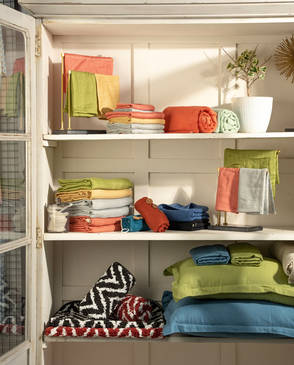 Colorful folded clothes on shelves in a well-lit room