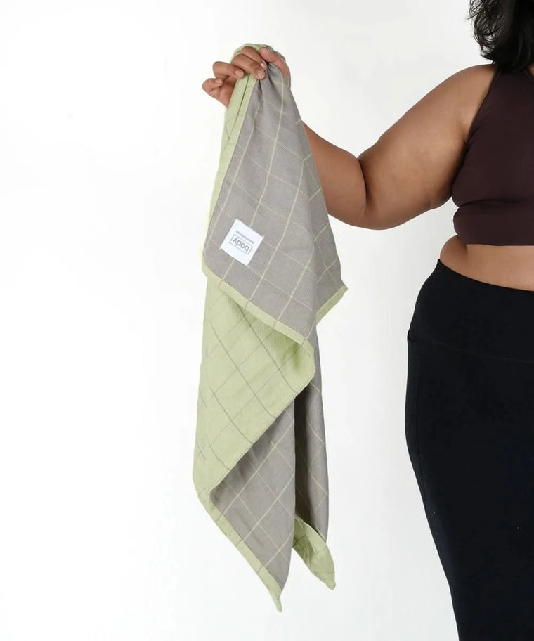 Person holding a Banana Double Cloth plus size bath towel on a white background