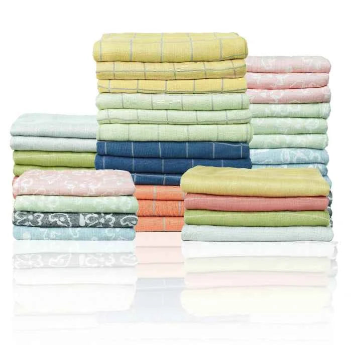 Stacks of folded fabric in pastel colors on a white background