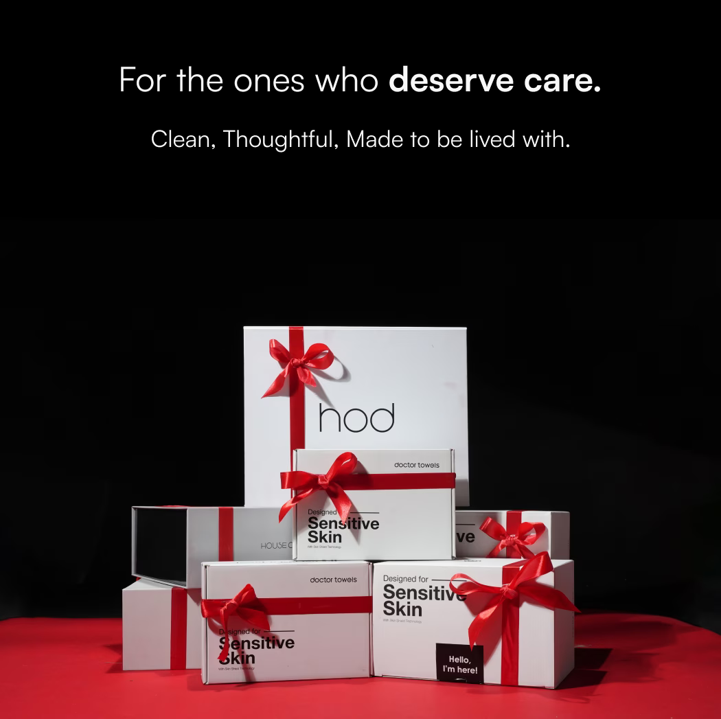 Stack of gift boxes with red ribbons on a black background for Christmas, featuring the brand 'hod'.