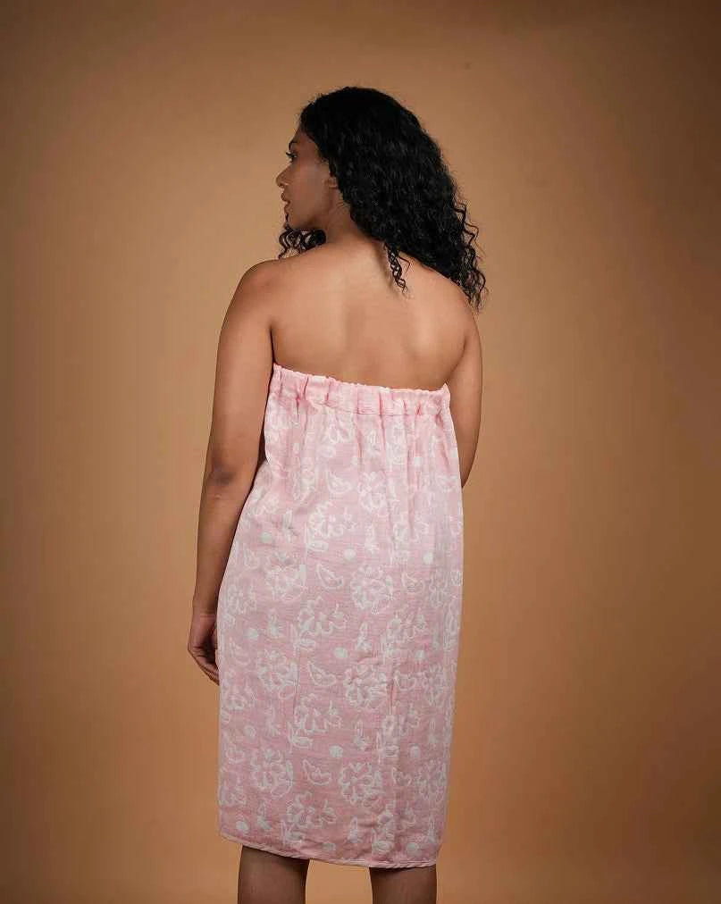 Woman wearing a pink floral strapless dress against a beige background