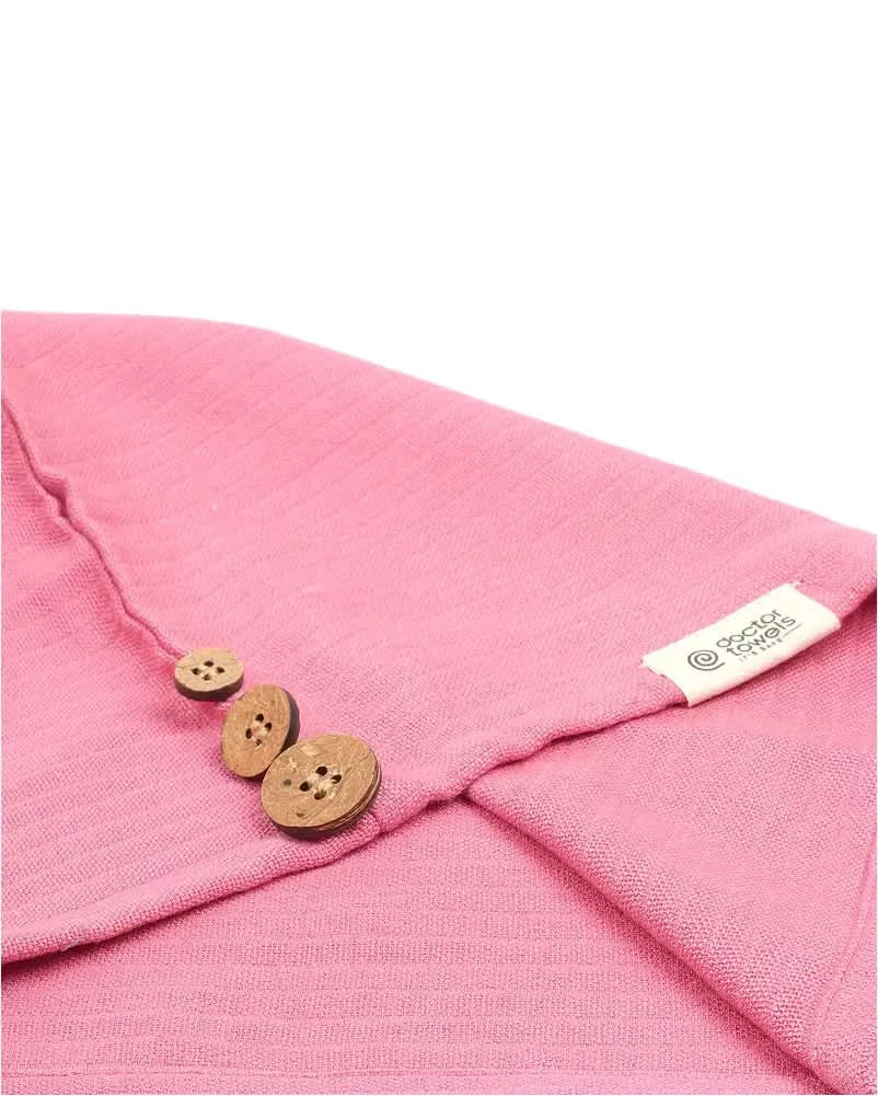 Close-up of a desert rose - banana double cloth hair towel with wooden buttons and a brand label on a white background