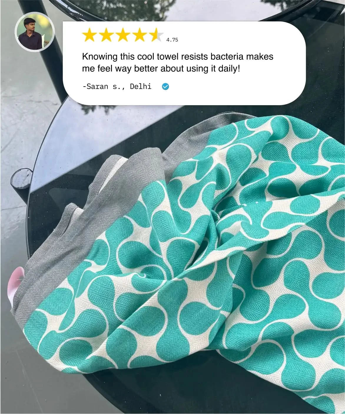 Teal patterned towel with gray border on a car seat, user review above.