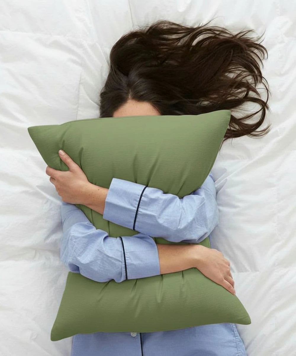 Person lying on a bed with a aloe green pillow - House of Doctor 