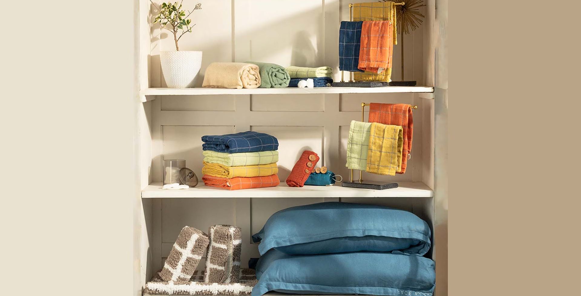 Shelves with folded towels and decorative items in a well-lit room.